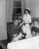 Nurse offering patient telephone at Wesley Long Hospital