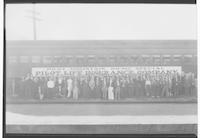 Group posing beside a Southern Railway car with a Pilot Life Insurance Company sign