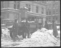 Workers shoveling snow at the intersection of Elm and Market Streets in downtown Greensboro