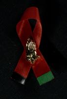 Red ribbon with praying hands pin