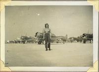 WAVES member in front of a line of North American T-6 Texan SNJ-5 aircraft