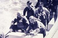Unidentified female Coast Guardsmen pilots a small rescue boat.