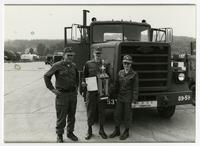 Captain Chin and two other U.S. soldiers pose with a trophy and a certificate