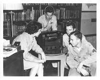 WAC and male soldiers around radio